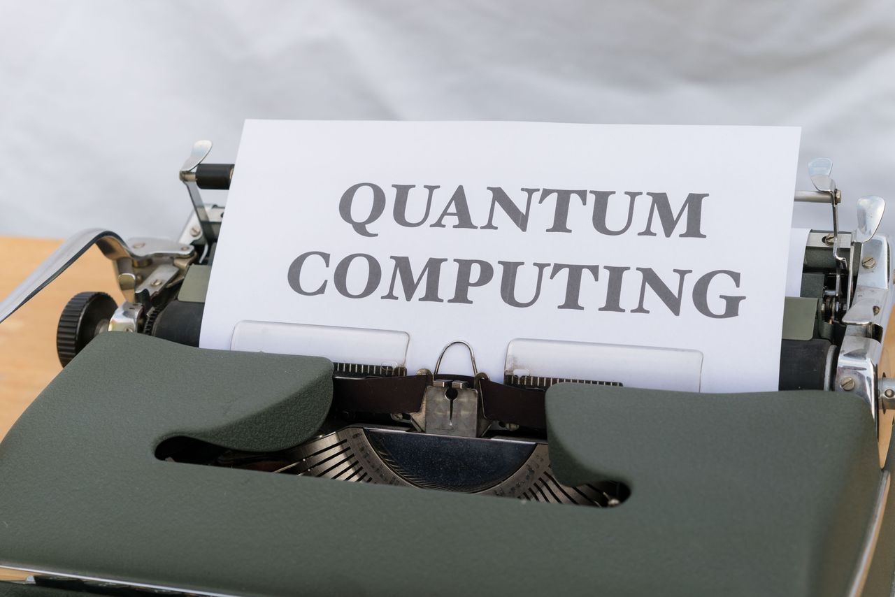 services-06 A vintage typewriter with a paper displaying the term Quantum Computing.