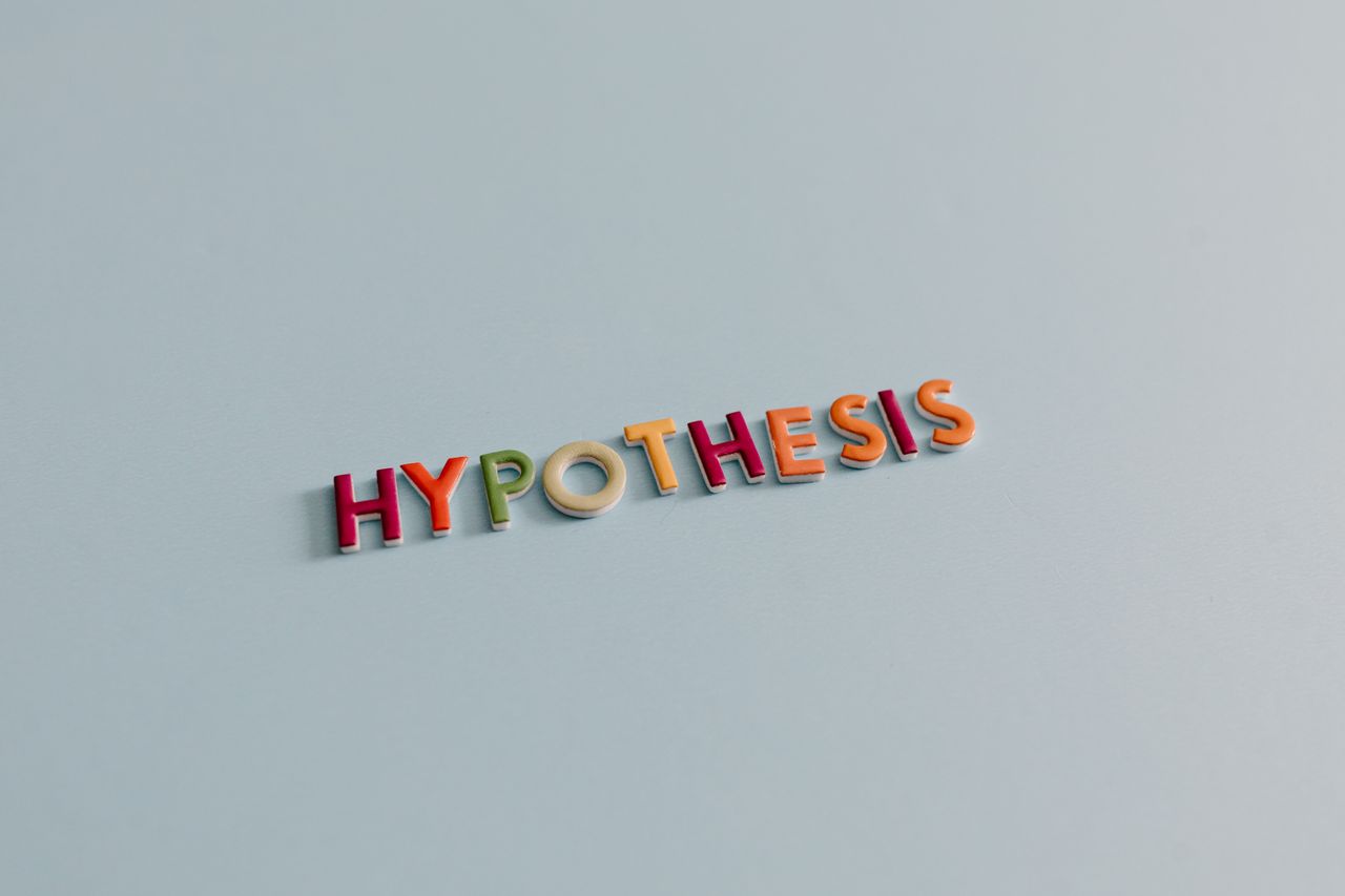 about-01 Multicolored letters spell 'HYPOTHESIS' on a light blue surface, conveying research and creativity.